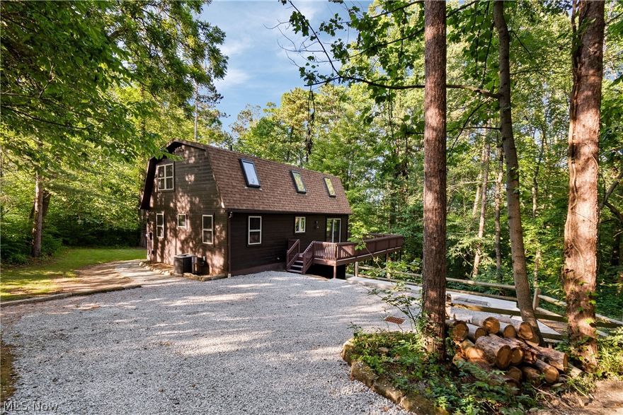 Cozy 3-Bedroom Cabin on 5.2 Private Acres Near Tappan Lake.  Welcome to your private wooded retreat in the desirable Tappan Highlands community. This charming 3-bedroom, 2-bath cabin sits on 5.2 secluded acres and is just a short golf cart ride from Tappan Lake, with exclusive access to a private community dock and beach.  The open-concept main level features a spacious eat-in kitchen and a bright living room with cathedral ceilings, skylights, and a wood-burning fireplace. Large windows fill the space with natural light while offering peaceful views of the surrounding woods. Pine tongue-and-groove ceilings throughout enhance the warm, rustic cabin feel.  The updated kitchen includes new stainless-steel appliances (with extended 3-year warranty), and quartz countertops, making it perfect for entertaining or everyday living.  Upstairs, the loft-style primary suite features skylights, a full bath with a luxurious solid-surface shower, and a sitting area ideal for a home office or reading space.  The full walk-out lower level is nearly finished and features recessed lighting, window, and full glass French doors leading to the backyard. This space offers flexibility for additional living space, a potential fourth bedroom, and already includes rough-ins for a third full bathroom.  Major 2025 updates include: New vinyl windows and exterior doors, Propane forced-air furnace, Central heating & air conditioning, New LVT flooring and carpet, Fresh interior paint, Newly stained cedar exterior, repainted deck, new concrete patio, stone driveway with concrete retaining wall, and a roof replaced in 2017.  Whether you're searching for a peaceful weekend escape, a high-performing Airbnb investment, or a full-time residence, this move-in-ready property offers the perfect combination of privacy, modern updates, and convenient access to Tappan Lake.