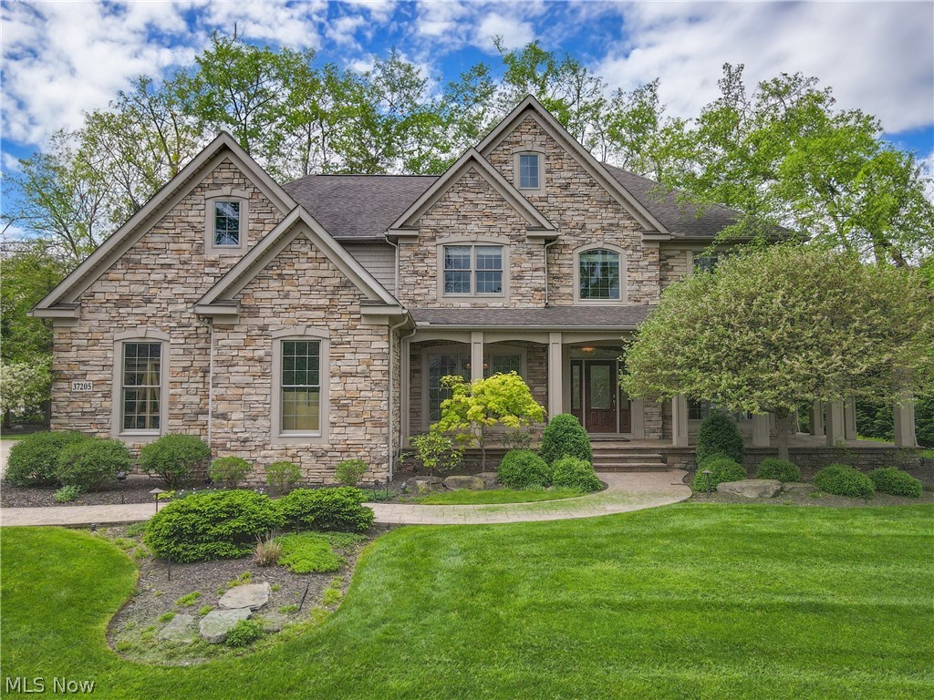 Step inside this enchanting Prestige-built home! Nestled on a wooded lot and boasting a charming wraparound front porch, this residence exudes sophistication and warmth. Gleaming hardwood floors grace the first floor, where you'll find formal living and dining rooms, a two-story great room offering picturesque views of the lush yard, a sleek modern kitchen featuring custom cabinets and granite countertops, a powder room, and a convenient first-floor laundry room. Upstairs, discover four spacious bedrooms, including a primary bedroom with a vaulted ceiling and a luxurious tiled en suite bathroom. Three additional bedrooms and two full baths complete the second floor. The lower level is a delight, with a finished space including a full bath and recreation area, perfect for hosting gatherings and parties. Outside, the meticulously landscaped yard features a maintenance-free paver backyard with an outdoor fireplace and barbecue facilities, inviting you to relax and enjoy the serene surroundings. With its original owner's meticulous care, this home is primed for its next chapter—come see it for yourself and experience the space and beauty it offers!