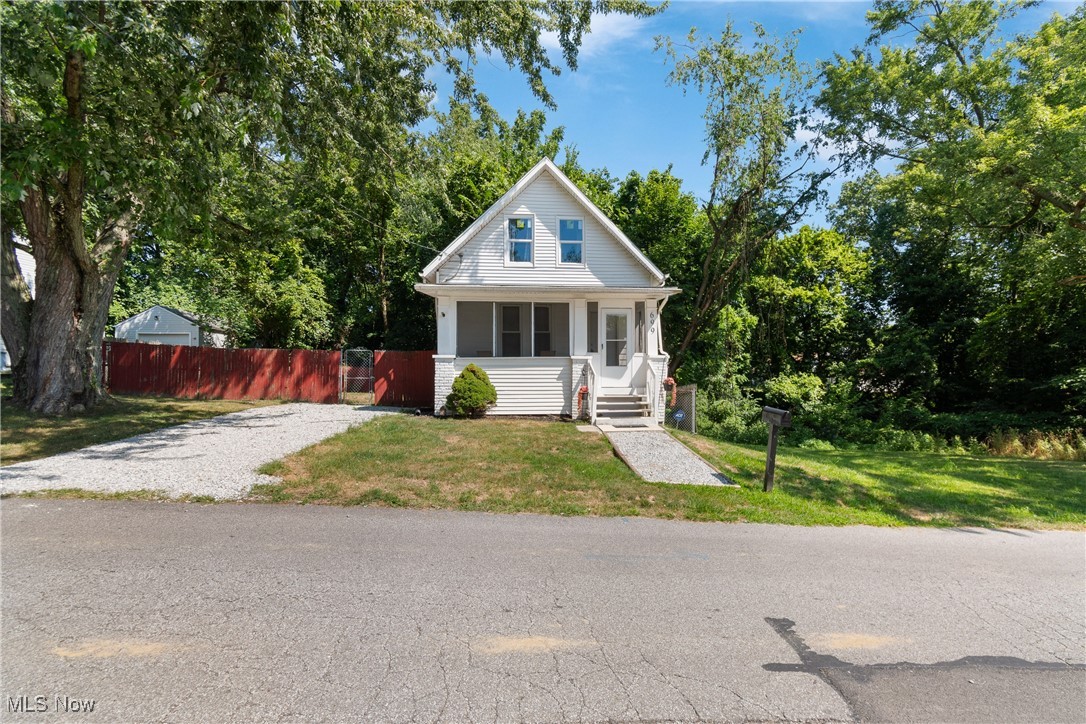 NOW! Look at This...Updated 2BR/1FB Cottage Core Cute! Cape Cod. Whether you're a first-time homebuyer or an investor looking for a turnkey property, this home is a standout opportunity. NEW Furnace and ductwork 7/25.Recent improvements include a new roof, vinyl siding, and some updated windows. The exterior features a fully fenced side and backyard and a freshly graveled driveway. A welcoming front porch sets the tone for relaxed evenings and casual entertaining. Light interior with high ceilings and abundant windows creating a bright, airy atmosphere throughout. The home has been freshly painted and has all-new flooring — luxury vinyl plank in the living and dining rooms, vinyl tile in the kitchen and laundry, and new carpeting in both bedrooms, each equipped with ceiling fans for added comfort.The updated kitchen features a new countertop, a stylish tile backsplash, an upgraded sink and faucet, and plenty of cabinet space for all your storage needs. A convenient first-floor laundry area adds practicality to everyday living. Full of cottage charm, this home is truly move-in ready and waiting for its next owner to enjoy.