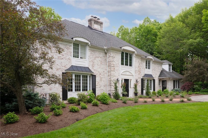 NOW INCLUDES 12 ACRES and NEW PRICE!!  Beautiful landscaping welcomes you to this Gates Mills residence with a hint of country French architecture and a bold statement of quality. A welcoming two story foyer with a transverse staircase sets the tone of refined design.  Beyond the foyer, the greatroom enjoys an expansive fireplace opposite a wall of arched windows overlooking the rear yard.  The greatroom flows seamlessly into the casual eating area attached to the custom-designed knotty pine kitchen.  A stone sink and large island accent the kitchen.  At the front of the home, the dining room has upscale finishes and extensive storage for tableware.  Across the foyer, the commanding, private office includes custom paneling, built-ins and drapes, all designed by Wendy Berry of W Designs.  Tucked into a back corner of the first floor, a room bathed in natural light and affectionately called the "sunroom", was redesigned to take full advantage of the views.  The star of the second floor is the owners' suite which incorporates a large, gracious bedroom, ante room entry way, dressing room with two attached walk-in closets and a recently remodeled spa-like bath.  The other three bedroom were updated with LVT and all have terrific closet space + charming details.  Another full bath on the second floor was re-done with a sophisticated look and high function, including two sinks and tub/shower.
The expansive, walk out lower level rec room includes a large seating area with fireplace and bar, a game table and pool table.  An exercise room with mirrors and plenty of storage is ideal for working out.  A full bath in the lower level is perfect for folks using the pool or enjoying the rec room.  
The lush, verdant gardens were masterfully designed and executed by a true landscape artist.  Something wonderful is always in bloom making the pool and patio feel like a fine resort.  Surround yourself in the beauty of the gardens.
Private + refined .Make this your new home.