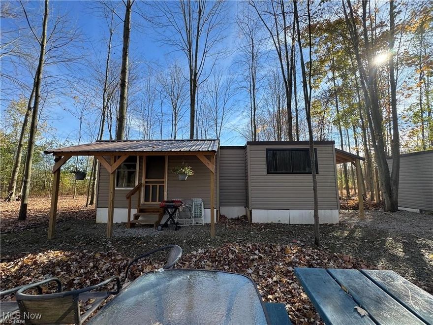Nestled on a lush, six-acre wooded lot, this charming property offers a tiny home with all the essentials, including fully functional plumbing, heat, and water—perfect for a cozy, move-in-ready experience. In addition to the tiny home, you'll find two versatile outbuildings: a spacious barn ideal for storage or hobby projects and a shed that offers extra space for gardening tools or outdoor gear. Wait- there's more! There's a mobile home that's a blank slate ready for customization. Whether you envision a guest house, workshop, or art studio, the home is ready for your creative touch.
