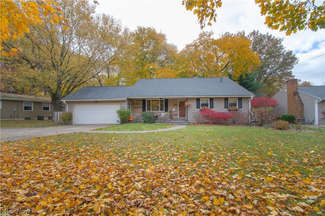 This North Canton home sitting on .52 acres is a must-see! An inviting covered porch creates a cozy feeling to this beautiful split level. Upon entering this home you’re welcomed by a spacious open-concept floor plan, a light color palette, and over 1,900 sq ft of living space. The great room features a brick accent wall, tall ceilings, and an abundance of natural light. Finishing off the 1st level is the stunning eat-in kitchen. It offers a large pantry, stainless steel appliances, a wine/drink fridge, an island with storage, a subway tile backsplash, and an oversized sink. Three bedrooms, a full bath, and a walk-up to the attic are on the upper level. The stunning full bath has a large vanity with a waterfall sink, a laundry chute, a tiled shower, and built-in storage right outside. The walk-out lower level features a full-wall stone fireplace with a mantle, built-in bookshelves, and gorgeous wood ceiling beams. The large park-like backyard features a covered patio perfect for entert