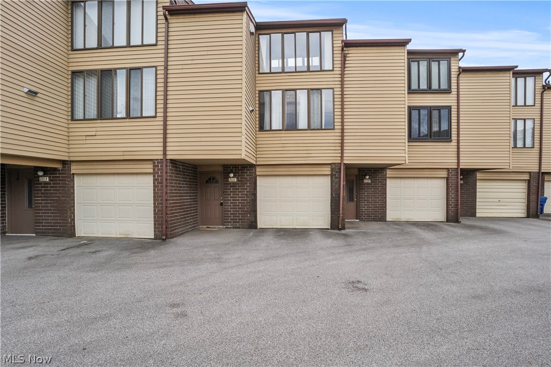 Here is a multi tiered Townhouse Condo located in a quiet community with close proximity to Portage Lakes, shopping, restaurants, and the highway. The lowest level has the foyer entrance, a laundry/utility area, a separate entrance from the single car garage and an open staircase to the main level. On this main level the floor plan is open and encompasses a large living room/ dining room combo, a galley kitchen and sliders to the deck porch. This condo is rustic and charming with exposed brick walls, large windows bringing natural light and an expansive wood beamed ceiling. There is a metal spiral staircase to the third level that includes the spacious loft bedroom and full bathroom.
The foundation of this condo has shifted slightly creating some unevenness that can be detected when walking on the main floor. Structural report available in the supplements. This is a great opportunity to own a reasonably priced condo in a well maintained community.