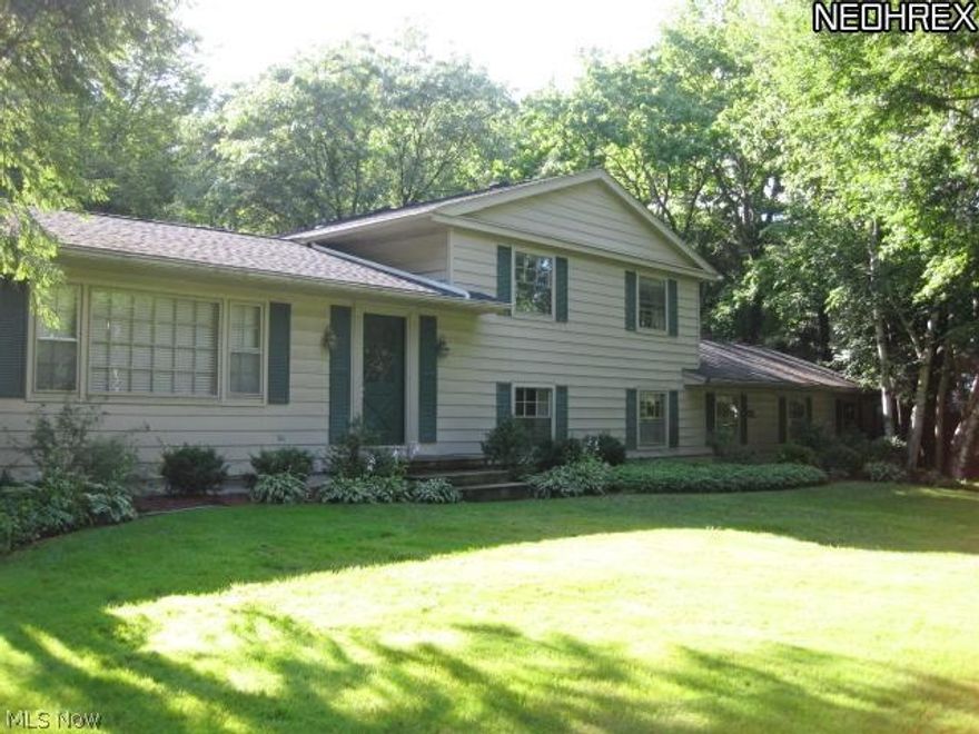 This unique contemporary split level home in beautiful Bath township has lots of surprises once you enter.  Foyer opens into huge family room with wet bar, one long wall of windows looks out to the serene private back yard and the other wall of sliding doors  provides easy access to the in ground pool. Just off of family room is the formal dining room with a built in grill.  Moving down the hall enter the great room with vaulted ceilings, gas fireplace, hardwood floors and opening to the updated kitchen with Corian counters,  breakfast bar and access to pool.  Up a few steps leads to three bedrooms and a full bath.  From the main level go down a few steps to the library/office, master suite, one more bedroom and full bath, spacious laundry/utility room, and attached 2 car garage.  Some replacements are air conditioner and furnace 2012 and 2nd furnace 2011.The beautiful 1.3 acre lot provides wonderful shade trees and lush and landscaping. A must see! Excellent price to sell quickly!