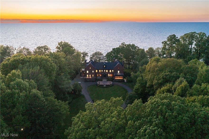 Situated on 3.5 acres along the Bratenahl coast of Lake Erie, this gilded-age grande dame underwent an extensive year-long transformation where the greatest of care was taken to bring the home into the 21st century. From the newly built bluestone patio and pool to the meticulously restored original door hardware, no detail was overlooked in perfecting this exquisite property. The grand front entry opens into an exquisite entrance hall where the full grandeur of the home is revealed. A testament to the craftsmanship of a bygone era, each wall is a work of art adorned with intricate carvings, a symphony of imported walnut and oak. Spectacular cut glass leaded windows, a hallmark of the first floor, cast prismatic light into the rooms, creating an ever-changing interplay of color and shadow. The grand dining room, equally impressive, boasts another fireplace and accordion doors that open into a breathtaking sunroom with polished marble floors and a stunning leaded amber glass skylight. Outside, a stone terrace steps down to the wet set bluestone patio and heated pool with a view of the lake and exquisite grounds beyond. A state-of-the-art Control4 smart home system has been seamlessly integrated, providing convenience and control at the touch of a button. Nearly every element of the home has been replaced or restored. All bedroom suites have been luxuriously equipped and can be found on the second floor. The third floor and lower level have been incredibly reimagined as entertaining areas for modern living. The original ballroom has been repurposed as a modern game room and home theater, and the lower level now functions as a private playground complete with a billiards room, a poker area, a bar with a temperature controlled wine cellar and tasting room, and a fitness center with a sauna. The original gate house has been beautifully restored into a 2-bedroom guest cottage.