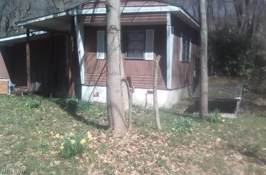 This mobile home plus room addition has the “bones” for a successful fixer-upper, but the greatest value of this property is in the lot and location, on a short dead end road, that has limited traffic. Surrounded by woods, it beckons to those who appreciate nature. The sunny backyard invites a veggie garden, backed by a strikingly beautiful poplar tree. Nearby is state-protected Wild & Scenic Conneaut Creek, with clear running water and small rapids, the Peet Nature Preserve (1.7 miles) with a nice Creekside trail, and beaches on Lake Erie(4.1 miles). 
But while “back to nature,” there is surprisingly easy access to town amenities. A grocery store, dollar store, and a family medical clinic all within (0.6 miles)
The added room provides extra space. The roof is holding up solid. It is connected to electric, but not activated. It has a furnace, but never used as it was only a summer place. There is city water available and it has a septic tank.