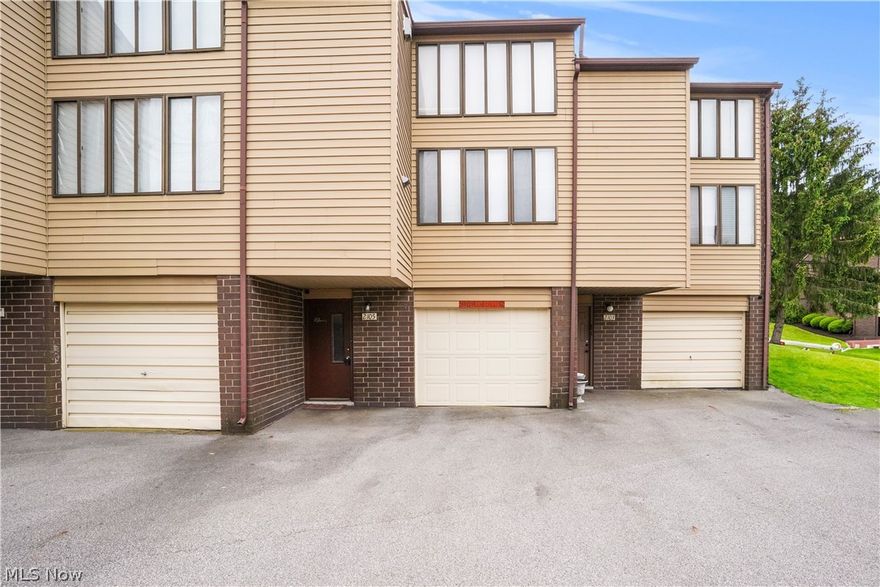 Here is a multi tiered Townhouse Condo located in a quiet community with close proximity to Portage Lakes, shopping, restaurants, and the highway. The lowest level has the foyer entrance, a laundry/utility area, a separate entrance from the single car garage and an open staircase to the main level. On this main level the floor plan is open and encompasses a large living room/ dining room combo, a galley kitchen and sliders to the deck porch. This condo is rustic and charming with exposed brick walls, large windows bringing in  natural light and an expansive wood beamed ceiling. There is a metal spiral staircase to the third level that includes the spacious loft bedroom and full bathroom. This is a great opportunity to own a reasonably priced condo in a well maintained community.