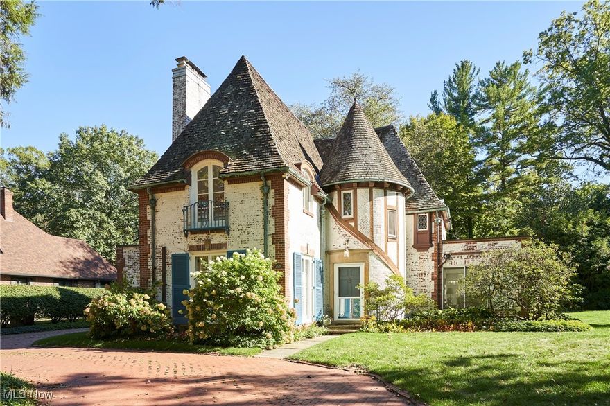 Rare treasure by celebrated architect Philip B. Maher of Chicago, with Interior Design by Robert Hunker. Nestled in Fairlawn Heights, this Normandy-style jewel was crafted in 1927 for the family of an adjacent estate. A rare opportunity, the residence has had only two owners and blends pedigree with timeless elegance, offering nearly 2,300 square feet of refined living. A turreted entry opens to a sunlit Living Room with soaring 10-foot ceilings and multiple French doors, creating an airy, gracious atmosphere. The adjoining formal Dining Room is equally inviting, flowing seamlessly into a glass-wrapped Sunroom—perfect for morning coffee or evening cocktails. A cozy Library with closet and powder room is located in a private corner and served as former live-in staff quarters. The vintage Kitchen, filled with natural light and custom built-ins, overlooks a surprisingly expansive backyard, ideal for entertaining or future gardens. Upstairs, three inviting bedrooms and two full baths (one en-suite) exude comfort and character, each space thoughtfully proportioned and each with windows on 3 sides. Many arched windows and doors, hardwood floors throughout and two fireplaces, including one in a bedroom, contribute to the incredible charm.   Additional features include a detached 2-car garage, waterproofed basement, and main-level central air and new boiler. Roof (tile) recently evaluated and updated. This historic gem captures the romance of Akron’s golden era while offering enduring livability. Call today to arrange your private showing of this special Fairlawn Heights home. Owner has handled extensive maintenance (using professional contractors) on the property over the last several years, including close to $100k updates/maintenance on tile roof.  Receipts available.