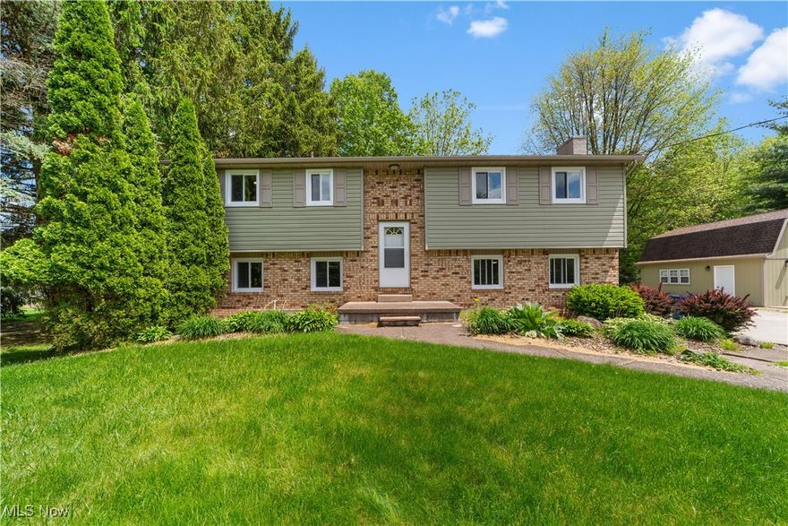 Discover a seamless mix of modern updates and rural tranquility in this renovated 4-bed, 2.5-bath bi-level on 1.6 private acres in Vermilion, with 2,244 sq ft of living space. This move-in-ready property delivers everyday comfort and versatility -ideal for families needing room to grow, hobbyists with projects in mind, or remote workers craving a quiet escape close to lakefront access, local shops, and dining. Enter through a bright foyer with new lighting, leading to an open upper level filled with natural light from brand-new windows. The living room flows into a dining area, offering space for family game nights or relaxed evenings. The spacious kitchen showcases rich cabinetry, stainless steel appliances, a breakfast island, and luxury vinyl flooring - perfect for quick meals or hosting. Step out sliding doors to a freshly painted deck overlooking open fields and stunning sunsets, your ideal spot for al fresco dining or summer barbecues. Upstairs, find three bedrooms with new carpeting, a full bath, and convenient laundry featuring a Maytag washer and dryer. Downstairs, a large family room with the crackle of a wood-burning fireplace (freshly painted) anchors the space, alongside a primary suite with private bath and a new half bath for guests - great for cozy fall gatherings as seasons shift. Key 2024 updates enhance efficiency and style: whole-house painting, new interior doors (including a barn door), trim, closet doors, wire shelving, lighting (fixtures, fans, sockets, switches), and stair handrails for safety. The new mini-split AC system keeps both levels cool and could cut energy costs by 20-30% (per EPA estimates) through Ohio summers. Outside, relax in the included hot tub under starry skies, entertain on the deck, or use the barn for storage or workshops. Garage upgrades add an EV outlet and motorized opener, supporting eco-friendly living. Enjoy modern comfort and privacy on acreage, with updated systems, scenic deck views, and a smooth interior flow.