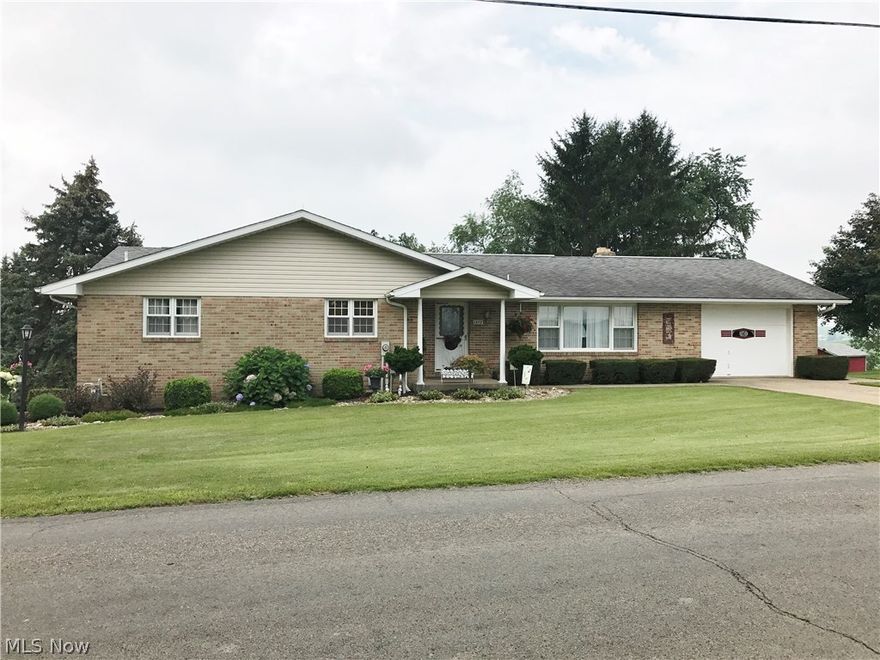 Auction 9/6-- Wonderful country offering with a good brick home, plenty of acreage for elbow room, all conveniently located only minutes from Sugarcreek or Walnut Creek. This home, built in 1966, features an all brick exterior along with a large Schrock’s kitchen and dining area, living room, master bedroom with full bath, 3 additional bedrooms, full bath, plenty of closets & storage, and a one car attached garage on the main floor. The full walkout finished basement features a spacious family room with brick fireplace, summer kitchen, laundry room with full bath, 3 seasons sun room, and a 2 car garage. Utilities to the home include gas forced air heat and electric heat, central air, public water & sewer, central vac, and a Generac whole house backup generator system. The lot features mature landscaping, concrete driveways and beautiful views. The vacant acreage is partially wooded with excellent development potential or building sites. If you want a ranch home on just a couple acres,