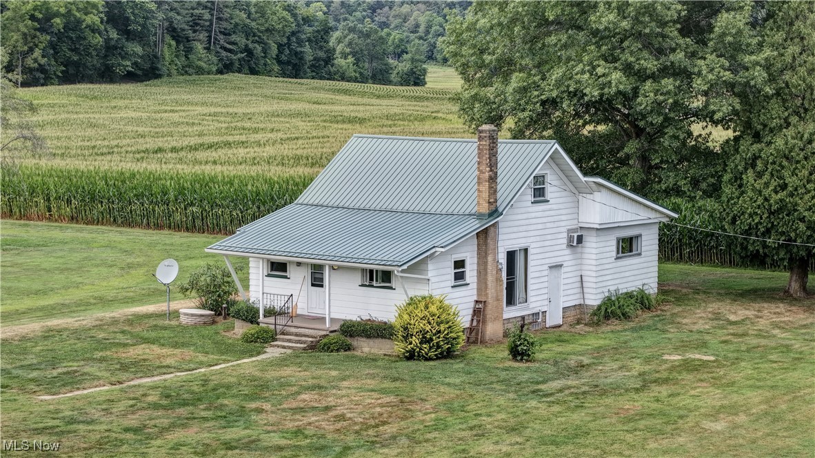 This solid 3-bedroom, 1-bath home sits on a spacious 0.7-acre lot, offering peaceful views and a quiet lifestyle backed up to a cornfield. Updates include new roof on home and garage and replacement windows. Inside, the kitchen showcases beautiful wormy chestnut wood and an abundance of cabinetry, perfect for anyone who loves to cook or entertain. The large living room provides a welcoming space to relax, while two first-floor bedrooms and a full bath offer convenient one-level living.
Upstairs finished space can serve as a third bedroom, home office, or playroom. The lower level is open and includes a laundry area, with plenty of potential for storage. Kitchen appliances and washer dryer will stay. With its large lot and serene surroundings, this property is waiting for someone new to make it their own. Located just west of Clendening and Tappan Lake.