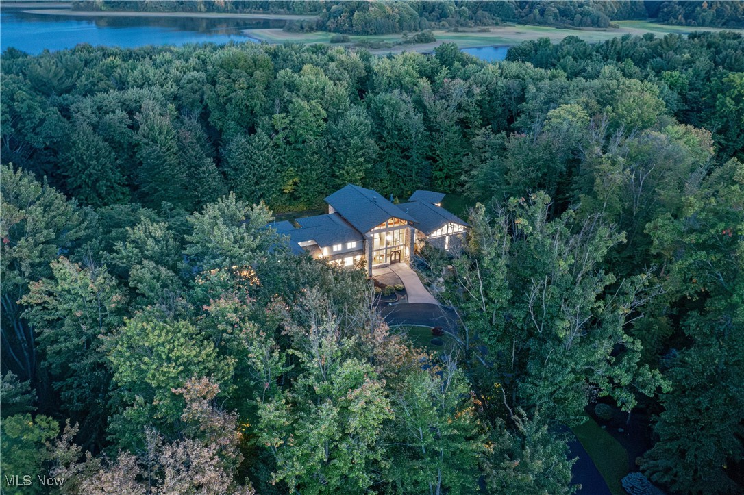 This stunning contemporary home blends elements of prairie style and Rocky Mountain architecture to create an unparalleled sanctuary. Completely reimagined and redesigned throughout, this property is without equal in terms of space, amenities, and design. From the zen lily pond and waterfall at the front entry to the perfectly arranged bluestone patio and pool, every element of the home has been perfected to provide a sense of calm and well-being. Every window of the home looks out to the serene, meticulously cultivated grounds complete with every imaginable amenity for open air entertaining, including a pristine pool, patio, pergola, fire pit, and deck. Enmeshed in stone and glass, the main living areas are stylishly appointed with wide plank white oak flooring, designer light fixtures, and sliding doors that open out for seamless indoor/outdoor entertaining. The chef’s kitchen is an absolute showstopper, complete with marble counters, an island, professional-grade appliances including a wine cooler, and a walk-in prep kitchen. Step out to the back patio and pool area, or step down to the stylish club level for beverages and billiards. The first floor owner’s wing is a stylish retreat optimized for relaxation. It includes an office with a private terrace, a spacious bedroom with soaring ceilings, a fireplace, and a floating stair that ascends to a loft that provides vista views of the grounds beyond. The private en-suite includes two vanities, a soaking tub, and an oversized step-in shower. The lower level has been completely redesigned as a state-of-the-art entertaining area, complete with a 19’ wine cellar, a custom illuminated bar, several game areas, a fitness center, and two full bathrooms. Outside, the resort-style pool and patio are surrounded by 3 acres of old growth trees, all backing up to Ladue Reservoir for unimaginable privacy.