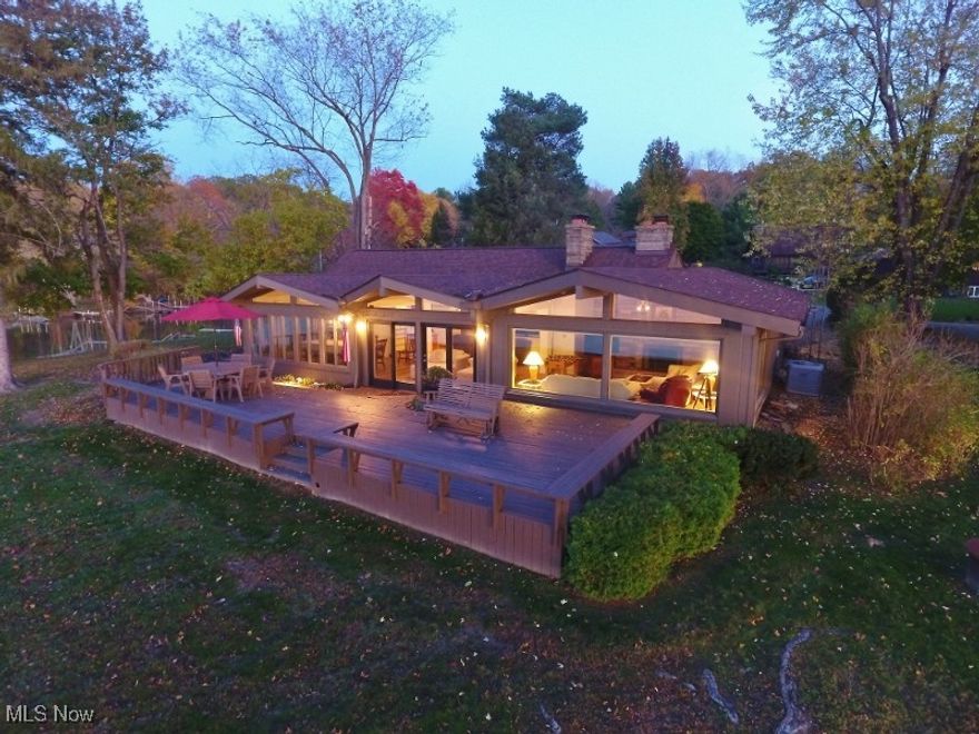 Experience the ultimate in lakefront living with this exceptional turn-key home, perfectly positioned on what many consider the finest waterfront lot on picturesque 1,540-acre Atwood Lake. From this remarkable vantage point, enjoy panoramic views that span more than half the lake — a truly once-in-a-lifetime opportunity to own such a rare Atwood Lake treasure. Nestled in the charming Atwood Village community, this impressive property offers 1,458 sq. ft. of living space complemented by over 1,300 sq. ft. of outdoor deck areas - both covered and open - designed to maximize the breathtaking views. Ideal for entertaining family & friends, the expansive wraparound covered deck seamlessly connects to a spacious 816 sq. ft. waterfront deck, perfect for gatherings, dining, or simply soaking in the scenery. Inside, the open-concept living area features vaulted, beamed ceilings, two fireplaces, & multiple inviting sitting areas, one of which could easily be reimagined as a stunning waterfront owner’s suite. The floor-to-ceiling glass front ensures that the sweeping lake views can be enjoyed from nearly every room — including the kitchen, dining area, and living spaces. Step outside to your private floating dock, just a few steps from the door, and take full advantage of all that Atwood Lake has to offer. The sprawling yard provides plenty of room for outdoor fun, while the attached two-car garage offers convenience and ample storage for vehicles and lake toys. This home is offered fully furnished, ready for you to move right in & start enjoying the lake lifestyle immediately. The unfinished lower level provides potential for additional living space, an extra bedroom, or bath if desired. Enjoy the annual July 4th fireworks display from the comfort of your own deck — with a front-row view like no other. Don’t miss this rare opportunity to own one of Atwood Lake’s premier waterfront properties. Leased lot — 2025 lease rate: $5,853. Be sure to view the detailed 3D virtual tour.