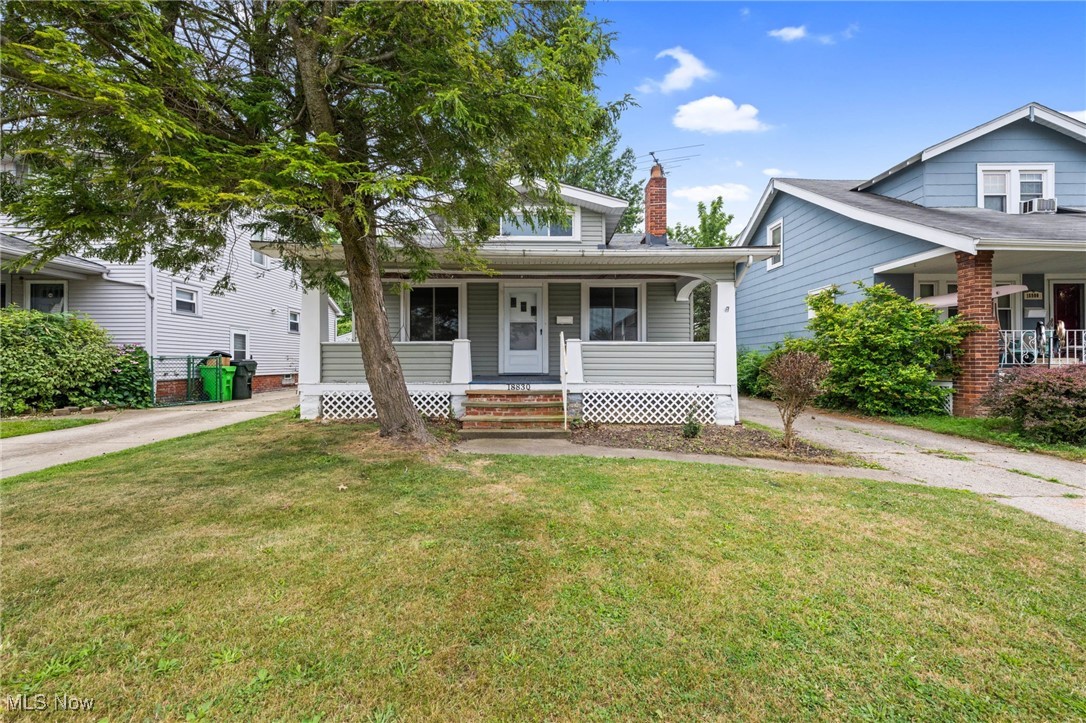 Welcome to this spacious and move-in ready 3-bedroom bungalow! A charming front porch with a swing invites you to relax and enjoy your morning coffee. Step inside to a bright and airy living room featuring a large picture window, decorative fireplace, and built-in shelving. The cozy dining room is perfect for hosting dinners and gatherings. The kitchen offers gray cabinets, open shelving, and black appliances—all included. Two generously sized bedrooms and a full bath on the main floor provide the ease of first-floor living, while the second floor boasts a large sun-filled third bedroom. Outside, you’ll find a fenced-in yard and a detached one-car garage. Conveniently located near Wildwood Park, shopping, and local restaurants. Don't miss your chance—schedule your showing today! The owner is a licensed agent in the state of Ohio.