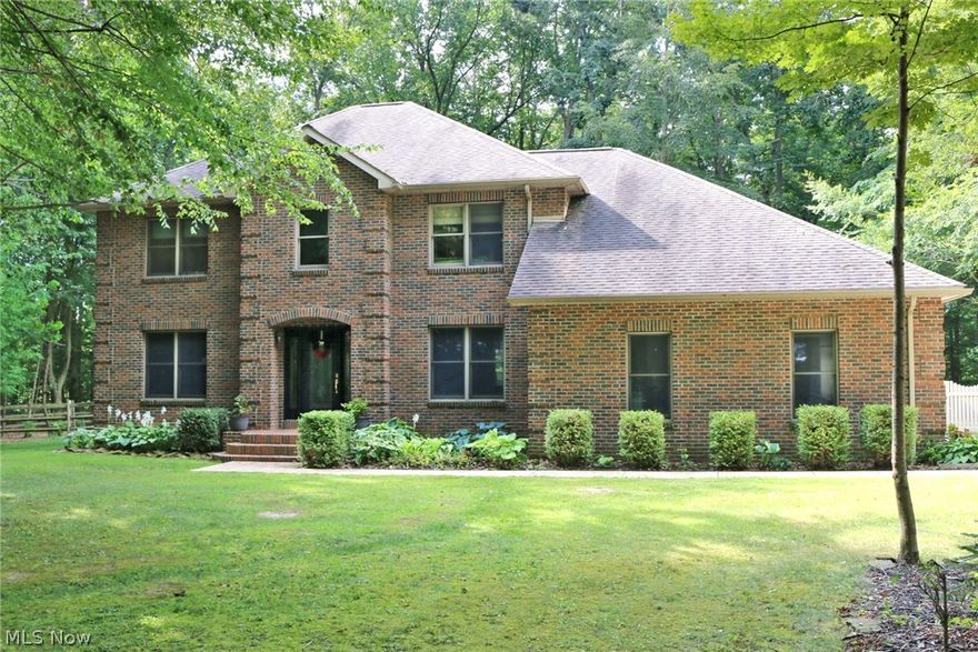 Amazing all brick colonial situated on over 2 wooded acres.  Upon entering the private drive, you will see this spacious home nestled in the woods.  The large back yard is fenced and has plenty of grass to play or house a garden.  There is a 33x28 brick outbuilding as well to house, toys, animals or vehicles plus an attached 2 car garage. The first floor offers spacious rooms  that include 1/2 bath,  1st floor laundry, spacious kitchen with center island and granite counter tops, eating area, formal dining room, family room with fireplace plus formal living room.  The lower level has a rec room that includes bar area.  Upstairs there are 4 spacious bedrooms, 2 bathrooms and large closest space.  The wall of windows across the back of the home provide a wonderful view.  This home is top notch and is situated on a beautiful lot.