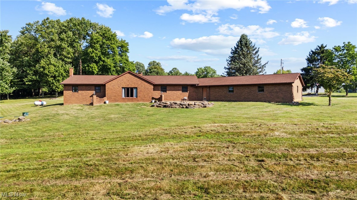 This spacious and updated property is a rare find in Malvern, Ohio! Sitting on 16 acres, this home offers flexibility and smart updates throughout. The main floor includes 3 bedrooms, 1.5 baths, the cathedral beamed ceilings add charm and character to the large living area, and an eat-in kitchen with peninsula. A bonus mudroom/flex room adds potential for office, playroom, or storage. Downstairs, you'll find a large family room, laundry, and an additional full bath—perfect for multi-generational living or entertaining. The garage space is unmatched: an attached 4–5 car garage, heated, finished, and equipped with a floor drain, plus a 40 X 74 detached outbuilding with electric and a concrete floor. Enjoy easy access to the backyard via three different exits, including a stone patio area off the main living area, kitchen walkout, and back door access—ideal for enjoying the above-ground pool and yard. Key updates: Roof, Sky Lights, Furnace, and Central Air (2020); Septic (2018). Also includes woodburner and electric baseboard zone heating. House does have free natural gas, just isn't hooked up to it, but is ran to the house. Don't miss this unique, well-maintained property that offers space, flexibility, and functionality—inside and out!