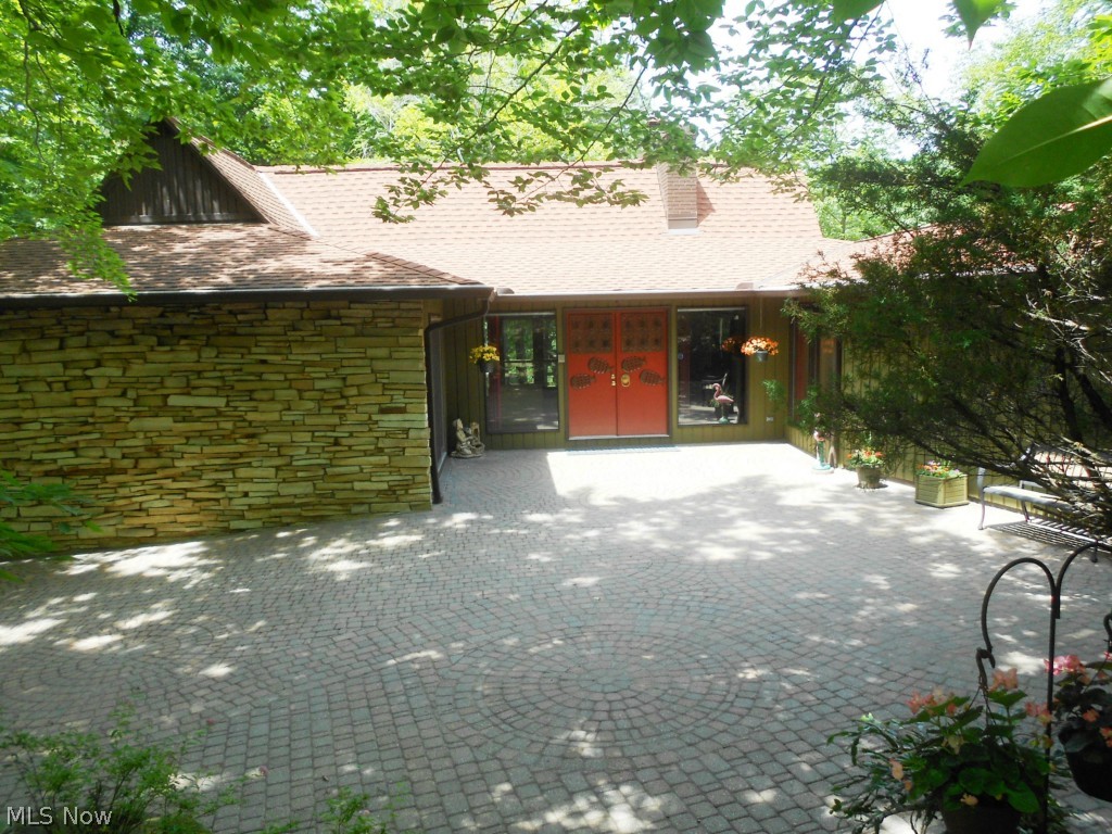 Expect the unexpected in this stunning property. You won't believe the number of times you say WOW. Boasting an impressive 66 foot wrap around porch, 3 fabulous patios & breathtaking views of the lake & woods, this house is not your typical home. Enter the lower garden by way of the private brick courtyard & brick/stone stairway. You can even fish or boat from the backyard canal. This home has been meticulously updated & maintained. The oak kraftmaid kitchen has newer granite counters, refrigerator & dishwasher & new carpeting accents the dining, living & family room. A vaulted family room offers skylights & sliders to the deck; additional sliders to the deck & yard make this home perfect for entertaining. The walk-out lower level features 2 bedrooms, a full bath, rec room with rare conversation pit, bar area, fireplace, bonus room, laundry room & sliders to the patio. Other updates include the high efficiency furnace & A/C (2014), newer roof, & newer deck & balcony flooring.
