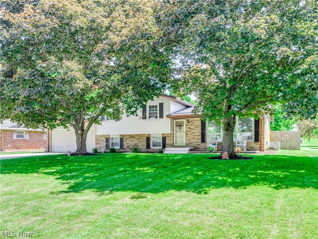 Welcome to this lovely split-level home! Before you even step into the home, you will be met by a large stamped concrete porch perfect for a couple of chairs to relax and enjoy the neighborhood. Enter into the foyer, which opens to a living room with hardwood floors with abundant natural light. The eat-in kitchen offers stainless steel appliances and laminate flooring. Off the dining area are doors to a wonderful three-seasons room with sliding glass doors to the private backyard. The family room offers a beautiful stone fireplace and walk-out access to the attached two-car garage on the lower level. The lower level also has a separate space/bonus room with two windows that could be used as an office or playroom. Upstairs the master bedroom has hardwood floors, a large closet, and a half bath attached—two additional bedrooms with large closets and a full bath complete the upper level. The backyard is large and has a big shed with electricity. Some update includes New metal roof (2021),