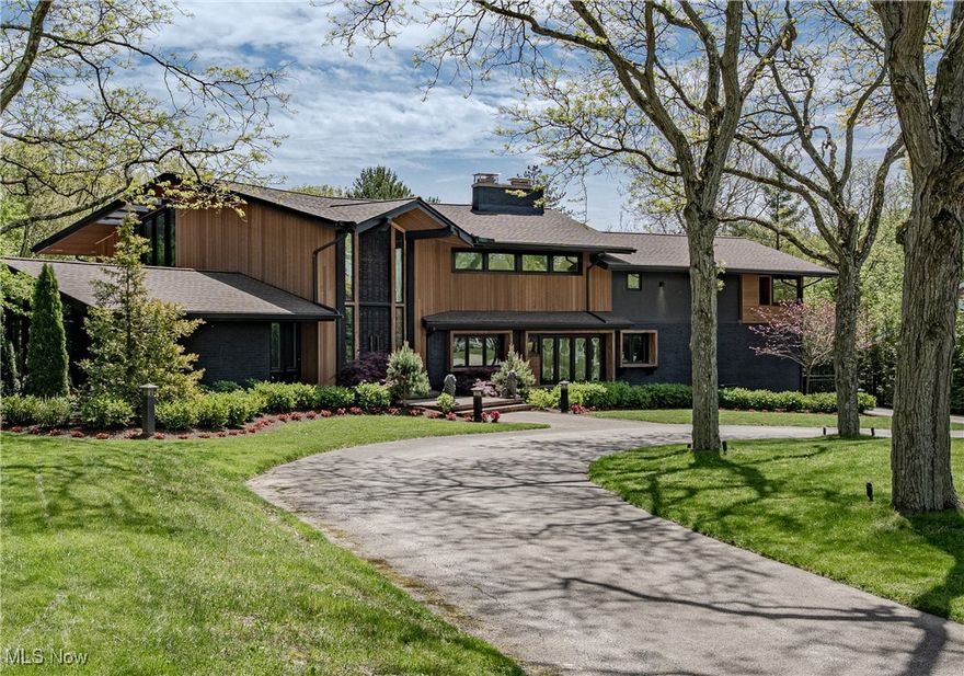 Curated Living Meets Iconic Mid-Century Form–Set behind a circular drive on over 1.3 acres of private, artfully landscaped grounds, this reimagined modern estate effortlessly fuses mid-century architecture with sophisticated modern enhancements. This residence is a sanctuary of refinement and seamless indoor-outdoor living. Meticulously renovated—main house, pool house, pool, outdoors, and grounds. Enter through dramatic hand-carved wooden double doors into an impressive foyer with the restored original staircase. Sunlight floods the open living areas, dining room, and chef’s kitchen with dual islands, high-end appliances, rich cabinetry, and a cozy fireside breakfast nook. The main floor also offers a private guest suite with en-suite bath and a powder room. Upstairs, the primary suite is an oasis with floor-to-ceiling windows and a spa-inspired bath; two additional bedrooms share a Jack-and-Jill bath, while an office/bedroom offers panoramic views of the tranquil grounds. The lower level adds a rec room. Step outside through 10-ft. custom sliding glass doors to resort-style living. You are instantly transformed into a world of leisure with a two-tier TimberTech deck, complete with a smart pergola that includes heaters and a louvered roof for opening and closing. The jaw-dropping oversized gunite pool can be controlled by an app and is framed by the elegantly tiled pool deck with a turf inlay. Landscape lighting, sandstone boulders, and perfectly placed landscaping have been thoughtfully installed to enhance privacy and ambiance. The cherry on top of this entertainer's dream space, the Forno Piombo Italian pizza station and integrated Sonos and JBL surround sound throughout the exterior! The transformed pool house offers over 789 sq. ft., complete with a game room, full bath, and pool storage. A rare fusion of mid-century style and Miami-inspired outdoor living, this one-of-a-kind retreat is a unique opportunity for unforgettable entertaining and everyday luxury!