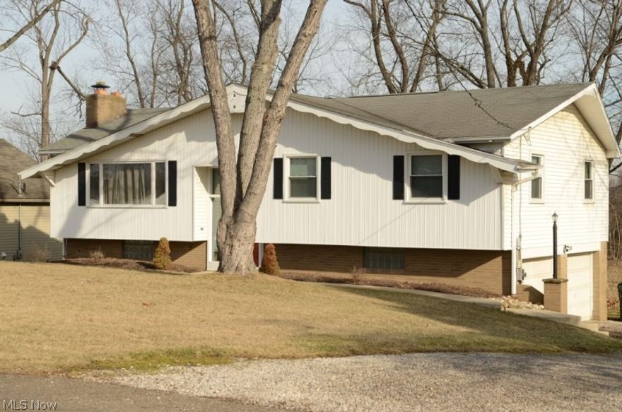 This darling home is situated in a wonderful area with a partially wooded back yard. The home features many recent updates, including new laminate flooring in entry, family room, living room, dining room, kitchen and two out of three bedrooms. The kitchen has loads of cabinet space with ultra-convenient features, such as pull out shelves, large drawers for pots/pans, lazy susan and a large pantry. The kitchen also has ceramic tile flooring, accent lighting and newer appliances. The great room has a brick fireplace and large picture window and is open to the dining room, which is open to the kitchen. The main bath has been completely updated with an eye-catching sink/vanity and ceramic tile floor. The master bedroom has a private half bath and double closet, while the other two bedrooms have lots of natural light from large windows and spacious closets. The walk out lower level has direct access to the deck, which overlooks the wooded back yard and fire pit. The lower level also exits t