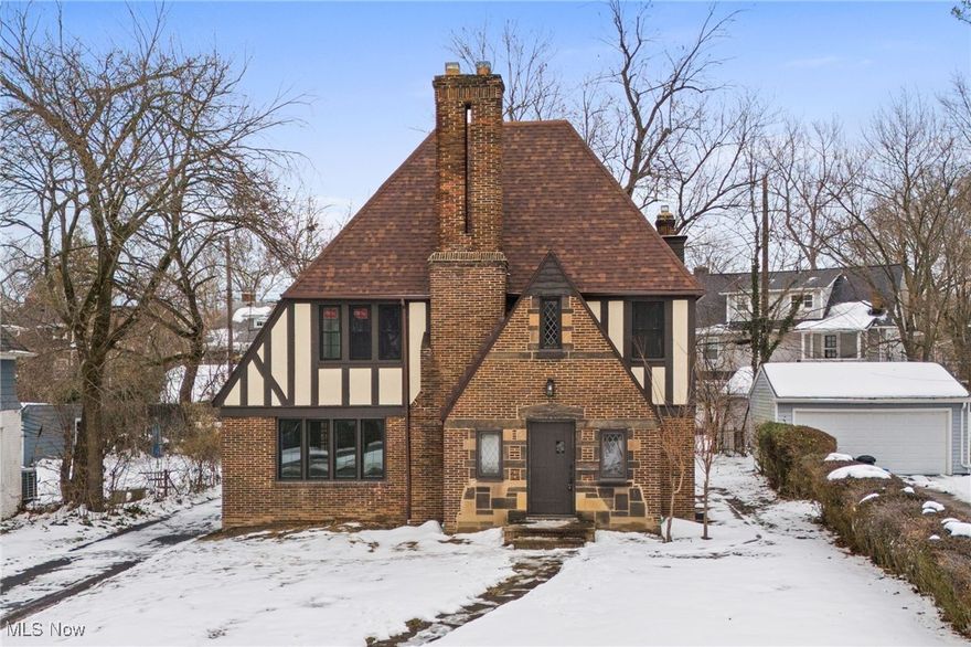 From the moment you arrive, this Shaker Heights Tudor makes an unmistakable impression with its brick exterior, steep gables, & classic half-timbering that immediately speak to it's architectural presence. As you step inside the home unfolds with intention & warmth. Where refinished hardwood floors flow & fresh paint enhance the natural light & original details. The great room is anchored by a fireplace & defined by original French doors with glass panes, leading to the formal dining room &  the sunroom, allowing the spaces to feel connected yet purposefully distinct. The dining room is ideal for hosting, while the sunroom offers a light-filled retreat for morning coffee or quiet moments, & a first-floor powder room adds ease to everyday living. The renovated kitchen blends modern updates with classic appeal, featuring white shaker cabinetry, quartz countertops, stainless steel appliances, tile flooring, & tasteful lighting selections that elevate each space without overpowering the home’s character. On the second floor a spacious primary bedroom with a sizeable closet & updated Jack and Jill bathroom. Three additional generously sized bedrooms are accompanied by a second fully renovated bathroom, offering comfort & flexibility. The third floor adds exceptional versatility, ideal as a private suite, teen retreat, the possibilities are endless, with ample closet space, bedroom, & full bathroom with a classic clawfoot tub. The basement remains unfinished for storage or future expansion. Beyond aesthetic updates & the restoration of character, this home is the definition of move-in ready. Apart from being POS complaint, many big ticket items have upgraded, including new roof(complete tear-off), gutters, windows, freshly seal-coated driveway, plus a home warranty for added peace of mind. Prime location within walking distance to Shaker Heights schools & close proximity to local amenities! This is a home that welcomes you the moment you arrive & invites you to stay.