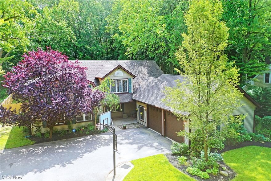 A stunning Lake County residence, this prominent home puts you just a short drive to Lake Erie while enjoying two floors of remarkable, move-in-ready living space! Set in the natural privacy of a scenic, tree-lined lot, a unique central patio bridges the oversized two car garage, leading to the decorative entry door. Gorgeous hardwood style flooring spills past the colorfully tiled fireplace that offsets the immersive kitchen, complete with bar top seating and a large center island as the inset range displaces the polished stone countertops. Ornate hanging lights shine off the stainless appliances that complete the look. Formal dining awaits the wood trimmed staircase as a posh great room steps up to showcase its expansive footprint. A charming full bath is located at the far end along with laundry and advantageous mud-room entrance. Near the basement entry, a second half bath completes the floor with fenced in backyard access just steps away. Upstairs, a tiered landing offers a short