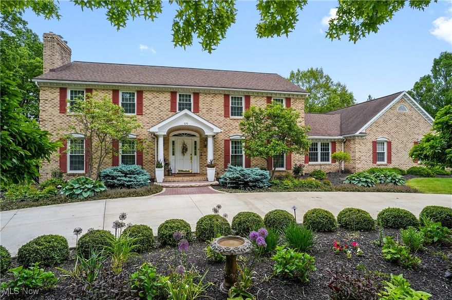 Exceptional all brick, custom-built Clapper home, nestled on a pristine 1 ac in Sanctuary of Bath, showcases superior craftsmanship & design throughout. Covered front portico leads to foyer featuring marble flrs & open, curved staircase that sets the tone for the home's timeless sophistication. Fr doors open to liv rm featuring a gas frpl & floor-to-ceiling windows that flood the space w/natural light. Formal din rm showcases wainscoting, cr molding, carpet & matching floor-to-ceiling windows. State of the art kitchen offers upscale appliances incl dbl ovens, center island, copper farm sink, dual bev center w/wine cooler, pantry cabinet & separate eating area. Fr doors open to vaulted sunroom that offers seamless access to family rm & sliding doors that lead to paver patio. Inviting family rm presents a brick gas frpl flanked by custom built-in shelving & wet bar. French doors open to home office w/beamed ceiling, built-ins & bayed window. Laundry rm offers ample cabinetry, granite counters, sink & storage closet. Back hall provides outdoor access & private staircase leading to generously sized 5th bdrm. A full bath & guest powder rm complete the well-appointed 1st fl. 2nd level showcases an exceptionally spacious primary suite, highlighted by a cozy fireplace, walk-in closet & a beautifully renovated glamour bath featuring a luxurious soaking tub, cabinetry w/refrig & walk-in shower. Add'l 3 bdrms, one ensuite & remodeled main full bath complete this level. Fin LL offers rec rm, mini-kitchen, wall of built-ins, multi-purpose rm w/sink, full bath, workshop & storage including cedar closets. Fabulous outdoor living space w/multi-level paver patio accented by barn stone, a curved pergola, built-in grill w/ fire table, dedicated dining area, koi pond & cozy firepit all framed by river birch trees. Landscape lighting enhances the ambiance, all set against lush landscaping and treed yard.  3 c gar w/epoxy flooring & Husky cabinets. HVAC '23, roof '11, Narragon irrigation