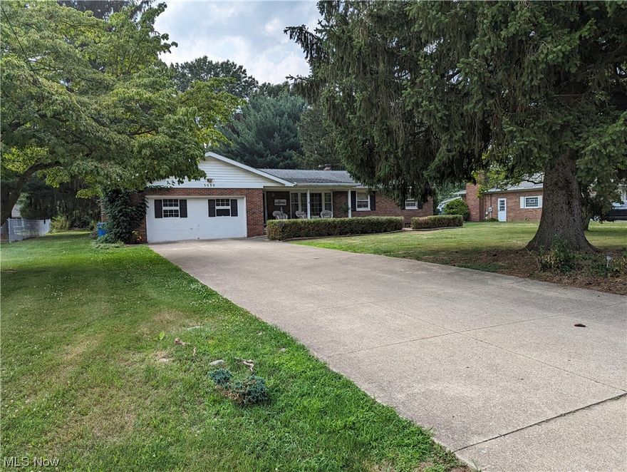 What an incredible opportunity to make this 4+ garage quality brick ranch house on a .46-acre lot in a relaxing neighborhood your new place to call home! Indulge in the nice location and convenience of being within miles of Portage Lakes State Park.

Step out onto the exceptionally inviting covered front porch to unwind with a good book or enjoy a morning cup of coffee. Upon entering this home is the primary living room with hardwood flooring and a sizable picture window. Enter the dining area as a fabulous focal point of the home with a delightful garden window. The oak-finished kitchen has abundant cupboard space and a range of utilities, including a refrigerator, microwave, dishwasher, and garbage disposal. Two bathrooms, each located conveniently on each side of the house. Three bedrooms are located on the right side of the home, while an additional cozy living area makes up the left side of the home with brick walls, a gas log fireplace, and access to a deck. The deck has a buil
