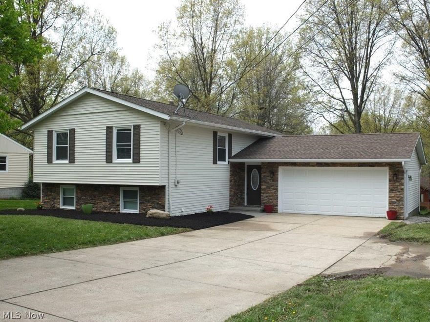 Wonderfully remodeled 4 bedroom, 2 full bath home with finished walkout lower level and open concept! Fantastic open main level has hardwood floors in the living room, dining room and kitchen. Beautiful kitchen has granite countertops, center island with breakfast bar, tile backsplash, pantry and comes applianced with stainless steel dishwasher, electric range, oven and over the range microwave. Master bedroom has a large closet and direct access to full bath with solid surface countertop, tile flooring and surround. 2 additional good sized bedrooms, also! Finished walkout lower level has a family room with stone fireplace, a huge laundry room with tile flooring, a fourth bedroom and a full bath with tile flooring and shower surround. 2 car attached garage, too. Backyard has a covered patio and a deck off of the dining room. Must see home with tons of updates!