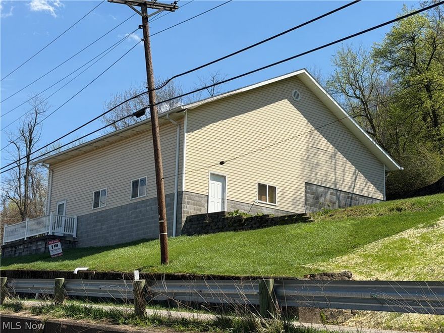 Located in Bridgeport Ohio, this one-story ranch offers privacy with mature trees and multiple outbuildings. The property features a 44x40 oversized detached garage with 2 13.6 Overhead garage doors with concrete flooring. Ideal for commercial use or a contractor's workspace with an additional oversized garage at the top of the hill provides ample room for outdoor equipment and storage. the home itself is a fixer-upper with strong potential, making this a versatile property for both residential and commercial business needs.