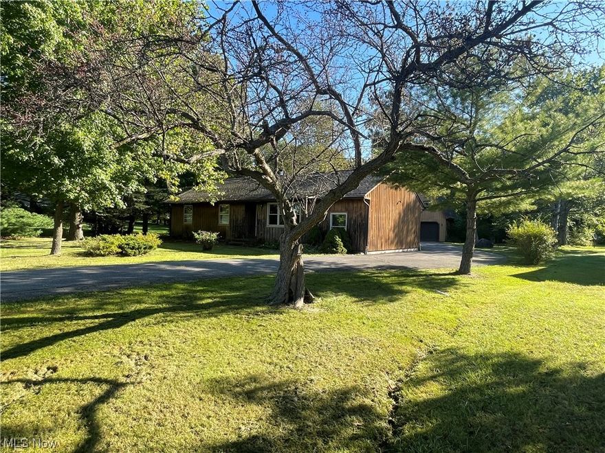 Concord Township Cedar-sided ranch on a crawl, .75 acre wooded lot, Country feel and privacy... Living room with large windows for natural light, dining room. Large oak eat-in kitchen with skylight, laminate flooring, pantry, fridge, oven, and microwave. Laundry room/closet with washer and dryer. French doors to step-down family room with brick fireplace. Oversize Master bedroom with full bath access, 2 additional bedrooms with hardwood flooring, ceiling fans. 11' storage/ mud room, 14 x 8 Covered deck, nice asphalt driveway, Cherry trees, 23' x 23' 2 story barn with staircase upper access plus 2 doors with space for two autos. Home warranty. Seller states the few ceiling stains are from before the roof was replaced. Make this your private retreat. Please see Broker Remarks!