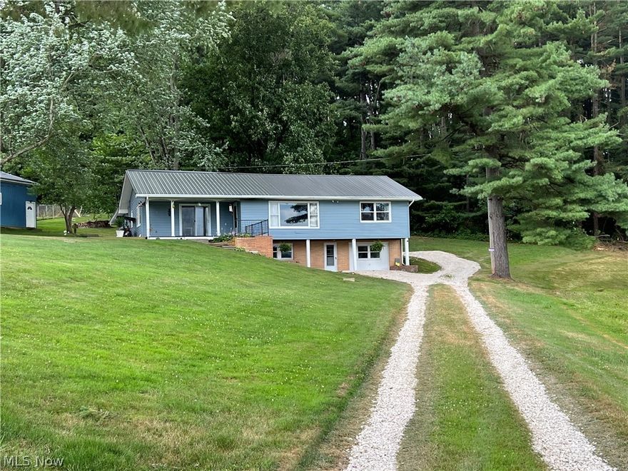 Charming 3-4 bedroom, 2 bath ranch home.  Island breakfast bar in the kitchen, open to the dining area with sliding glass doors to the covered patio and spacious deck.  Hardwood floors in the bedrooms.  Tastefully remodeled full bath with double sinks.  Finished, walk out lower level features a rec room with decorative brick fireplace, 2nd kitchen, bedroom, full bath and laundry.  Lower level is ideal for an in law suite.  Vinyl replacement windows.  New metal roof in July 2022.  1 car attached garage.  44 X 32 pole building with 12' ceilings, car lift and two 10' overhead doors.  Country setting, just outside of town on 1.66+/- acres.  Car lift not warranted.  Exclude range in lower level.  Decorative fireplace can stay.