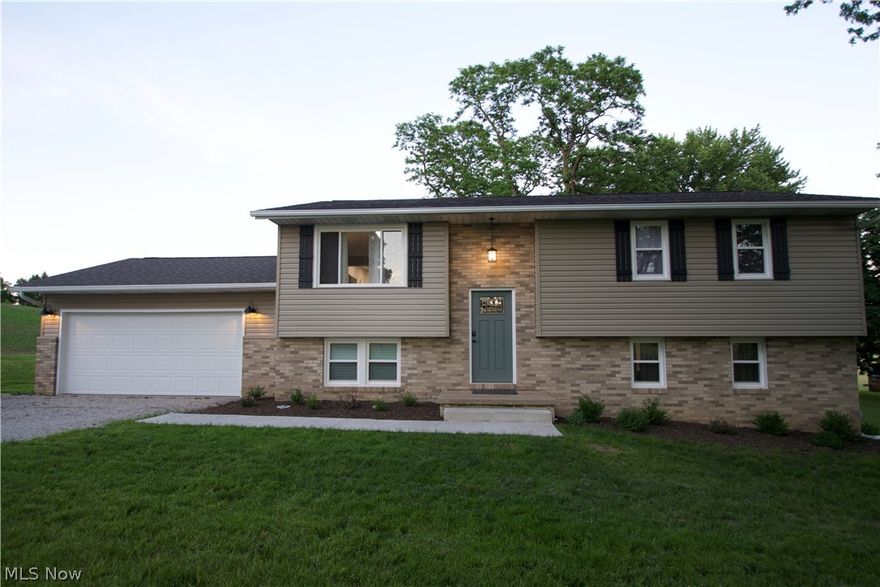 Completely remodeled bi-level in West Branch Schools. Situated on almost an acre of land off a quiet street - all the breathtaking views of the country while still being close to town! This home has been completely redone from the inside out, and top to bottom. All new windows, exterior doors, siding, landscaping, and roof (2019). New interior doors, trim, flooring, drywall, and fresh paint throughout (2020). Entry boasts custom iron rails with black walnut accents and opens to the large upper level living area. Kitchen (remodeled in 2020) includes custom built cabinets with quiet close drawers and doors, built in pantry, top of the line new appliances, large farmhouse sink, and granite counter tops. Beautifully custom designed black walnut fireplace mantle and surround with electric fireplace insert accents the downstairs family room. Entry from the garage and back patio is accented with wainscoting and gorgeous laminate flooring. Full bathroom installed downstairs; both it and the up