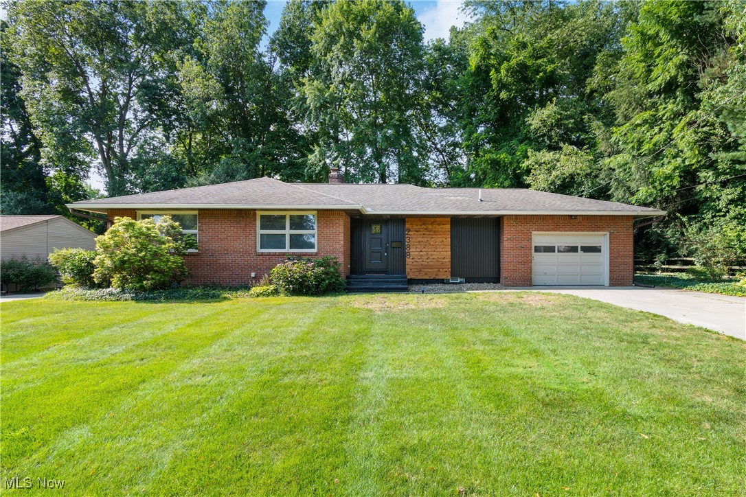 Step into this stunningly reimagined brick ranch—boasting over 2,600 sq ft of beautifully finished living space, 3 spacious bedrooms, 2.5 designer bathrooms, and a convenient attached garage. Located on a quiet street with eye-catching curb appeal, this home will instantly stand out to anyone passing by. Inside, the open-concept layout welcomes you with panoramic views of the serene backyard and golf course through expansive picture windows that flood the space with natural light. At the heart of the home lies a show-stopping 9-foot kitchen island, adorned with luxurious Calcutta Quartz countertops. The fully redesigned kitchen features sleek black fixtures, a brand-new stainless steel appliance suite, soft-close 40” upper cabinets, oversized drawers, a hidden trash pull-out, pendant and recessed lighting—all crafted for both style and functionality. The oversized living room showcases a dramatic floor-to-ceiling brick fireplace flanked by built-in shelving—perfect for cozy nights or entertaining guests. Just off the main living space, the versatile dining room or home office is a true retreat with floor-to-ceiling windows, a sliding glass door, accent wall, built-in bookcase, walk-in closet, and its own mini split for comfort year-round. The primary suite offers dual closets with built-in shoe racks, a modern ceiling fan, and a spa-inspired ensuite complete with a custom tile shower, modern vanity, and matte black finishes. The stylish guest bath includes a tiled tub/shower combo, niche shelving, and updated fixtures to impress. Downstairs, you'll find a huge fully finished rec room with durable LVP flooring, recessed lighting, and a convenient half bath—perfect for a game room, movie night, or home gym. Plus, enjoy a spacious laundry area with cabinet storage, folding station, and a dedicated utility room for all your tools or hobbies. Agent-owned. This move-in ready home checks every box—don't miss your chance to tour this exceptional property!