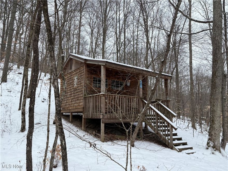Your weekend paradise awaits!! 47.75 Acres in Guernsey County. Minutes to I-77. Secluded cedar shake sided primitive cabin with perfect porch for rocking away the evening. Cabin has new roof installed. Excellent privacy on low traffic count paved county road. Cleared trail system throughout, top shelf whitetail and turkey hunting on property. Clearing above cabin is the perfect location for a food plot system, with preavailing winds to your advantage for access and egress.  Large gulleys lined with massive boulders are an explorers dream and create natural funnels for wildlife. Large stream at road stays open throughout winter season, and creates a natural barrier to maintain privacy and access. Seller does not own mineral rights.  Priced to sell!