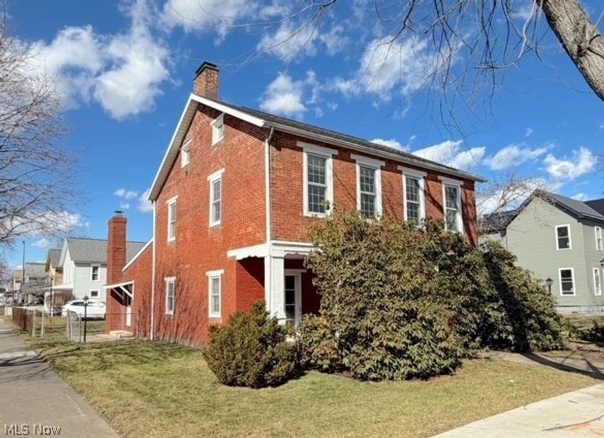 Historic Heritage Home of Tuscarawas County. This brick beauty is full of character and potential. Inside, you will find generous room sizes, tall ceilings, and unique features that reflect craftsmanship from another era. There are 3 bedrooms, 1 1/2 baths, a first-floor laundry room and a separate addition that could easily be turned into a main floor master suite or home office area. There is an impressive foyer with an open staircase. There are 3 fireplaces. The living room has hardwood floors, a fireplace, and a lot of natural lighting. The spacious kitchen has a center island, a corner fireplace, and plenty of cabinetry. This home was built in 1841 and has 2606 square feet. There is an enclosed sunporch and a 12x30 detached garage. It is situated on an 88x130 corner lot. This home sells as-is to a cash or conventional loan buyer only. The seller will not make any repairs and will make no disclosure on the condition of the property. This home will require some updates, but the solid structure and timeless character provide the perfect foundation for restoration, investment potential, or transforming it into a beautiful personal residence.