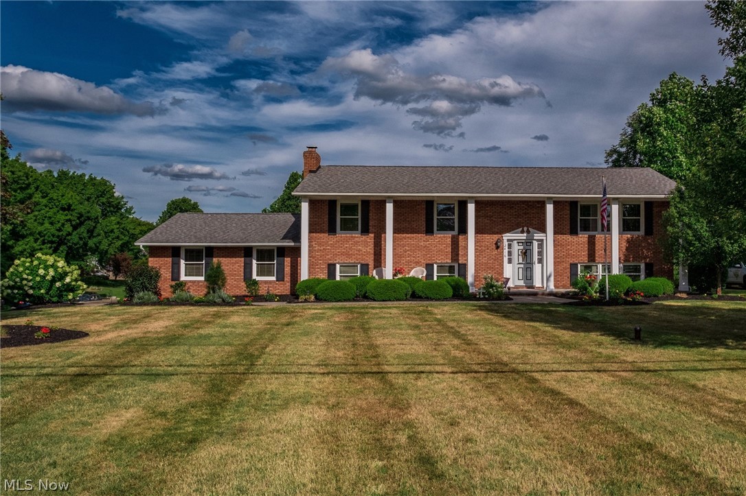 This custom built approx. 2600 square foot bi-level brick home welcomes you at every turn! And, it is located in desirable Lake School District. Family space is plentiful with the 4 BR/3 full baths. With its Georgian-style architecture, you can enjoy beautiful views from the 50ft long front porch, and the 12x24 rear deck which opens from the master bedroom and kitchen. The lower level invites you into the family room, where your attention is drawn to the impressive stone fireplace and beamed ceiling. Enjoy your favorite beverage at the bar, or take the party to the covered outdoor patio for easy entertaining or a soak in the hot tub. You will also appreciate the amount of available storage this level provides. The beautifully landscaped exterior wraps around the home with visual interest and color throughout the seasons, and the .51 acres lot offers great outdoor area for children, or peaceful repose. And wait until you see the amount of shelves and storage the oversized 2 car