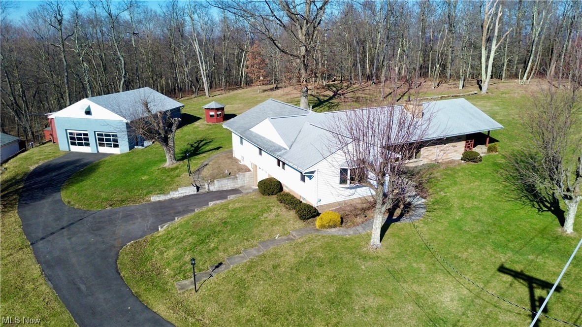 Beautiful, large mid-century home set on a sprawling 1 acre lot. This home welcomes you into a large living room, complete with stone fireplace, and flows into a large dining room. Off the dining room is the kitchen with adjoining family room area and fireplace. Patio doors from the kitchen open onto a covered patio. The main floor features a large master bedroom with en-suite, along with 3 other bedrooms and another full bath. Downstairs is finished and features a garage, full bathroom, and workshop. Outside, you will find an extra-large garage with a spacious loft and a lean-to that easily accommodates a RV or boat. Additional detached structures include a one car garage and an unusual hexagonal building that served as a children's playhouse.