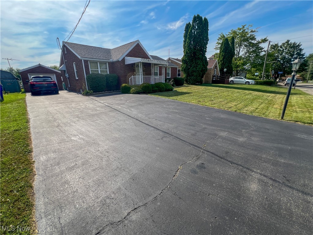 Brick ranch home with a detached garage and fenced-in yard. The home's first floor has a large living room, dining room, kitchen, three bedrooms, and a full bathroom. The basement is partially finished with a family room, kitchen, a half bathroom, and laundry. The basement also has a workbench and shelving. The front of the home has a covered front porch (6'x10'). The back of the home has a covered patio (7'x20'), detached brick garage (13'x22'), a shed (8'x10'), and a rear section of privacy fencing. The basement carpet is new, new outdoor carpet on both patios, and a newer central air conditioning unit.