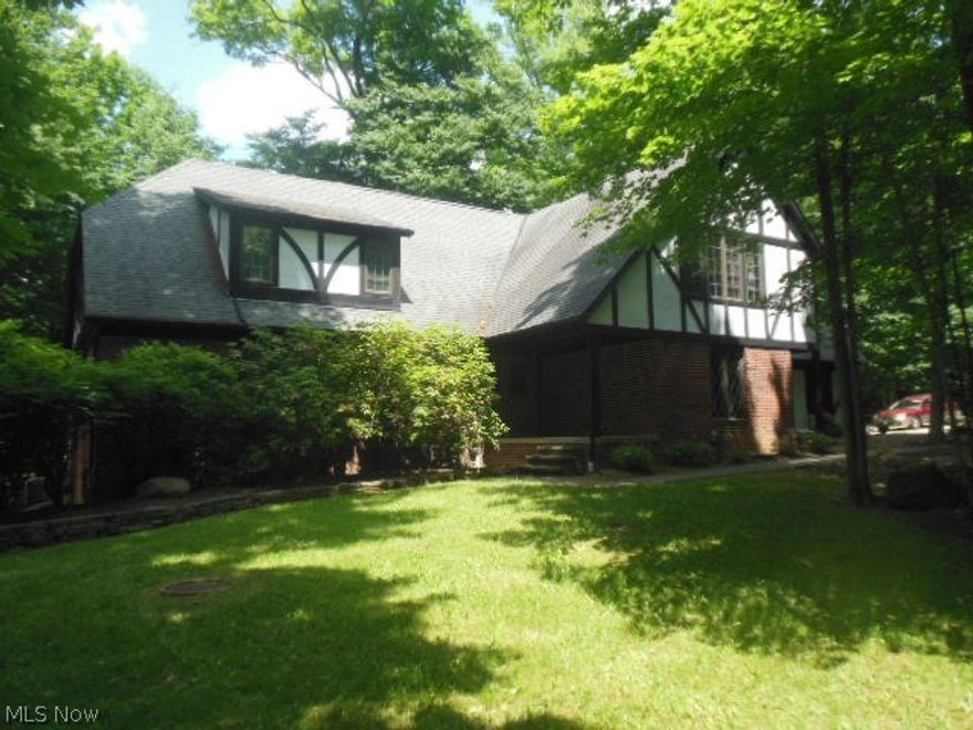 Enjoy the tranquility of Nature. Stately tudor offers wooded views from every rm. Spacious rms through out. Morning rm off kitchen with window walls ,overlooks the rear yard with small ravine & babbling brook. 2 story great rm with 2story window wall & fireplace.Living rm and formal dining rm, updated kitchen,study,  full bath, laundry on 1st fl. 2nd fl has 4 bedrooms,  2 full baths & loft with fireplace. Lower level is walk out, fireplace & large windows. Lower level  accessed from interior, garage. Walk all the way to end of walk to the front door, stone patio in front, deck/balcony off 2nd floor  family room.