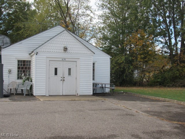 View of outbuilding with view of wooded area
