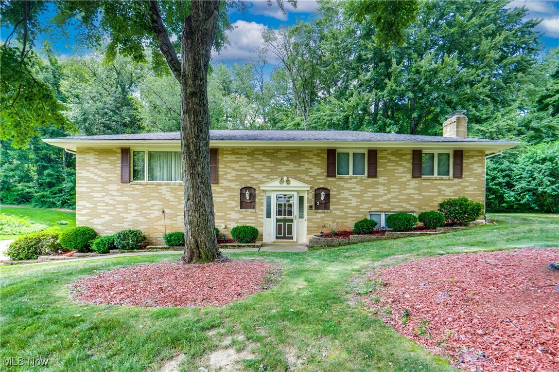 We're thrilled to bring you this well maintained one owner home in the highly desirable Lake Local School District! Tucked away on a beautiful tree-lined street just minutes from Route 619 and Cleveland Ave, this meticulously maintained brick bi-level offers space, privacy, and charm. With four bedrooms, three full bathrooms, and over 2,200 finished square feet—including the finished lower level—this home has room for everyone! The main level features a HUGE living room that opens up to the dining room. The eat-in kitchen features newer vinyl plank flooring and well-maintained cabinetry and counters. Three bedrooms and two full baths round out the upper floor, including a primary suite with its own private bath. Downstairs, the lower level features a cozy family room with wood-paneled walls, neutral carpet, and a brick accent wall that showcases a gas fireplace insert. You'll also find the fourth bedroom, another full bath, and a laundry/mechanical room. Enjoy your mornings or evenings in the 3-seasons room that opens to a private deck overlooking the wooded backyard. There is an additional storage shed under the deck, providing outdoor storage options. Additional features include an irrigation system and oversized two-car attached garage. HVAC replaced in 2021. Schedule your private showing today!