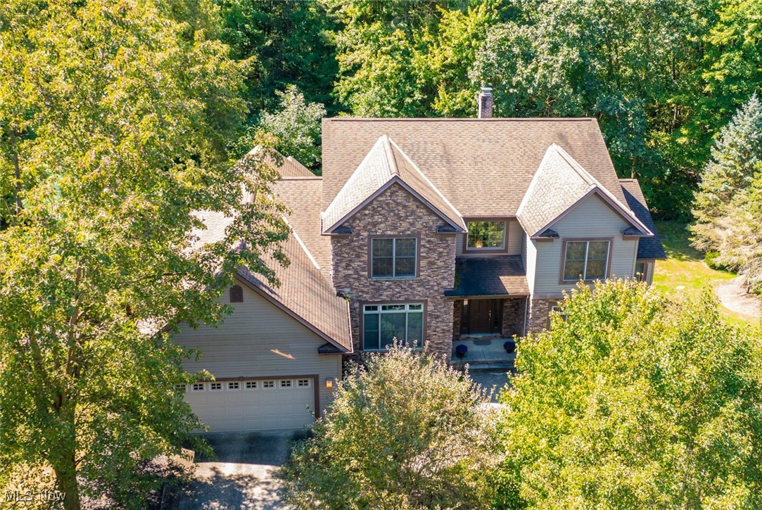 Striking Transitional home on a desirable cul-de-sac! Step inside the Foyer and into the dramatic two-story Great Room, highlighted by a soaring floor-to-ceiling stone fireplace flanked by custom built-ins and a wall of windows with access to the expansive back deck. Gleaming hardwood floors flow through the main rooms, including the spacious Dining Room with tray ceiling and recessed lighting. The Eat-in Gourmet Kitchen features a center island with granite counters, stainless steel appliances including a Jenn-Air gas cooktop and oven, and a generous dining area. A delightful screened porch off the Kitchen provides the perfect spot to relax. The versatile Den off the front hall can serve as a media room or home office! First-floor Primary Suite offers a walk-in closet with custom organizing system, and a spa-like bath with jetted tub and stall shower. Convenient Laundry Room and guest Half Bath complete the main level. Upstairs, a spacious Loft area leads to two Bedrooms and a full Bath in hall. The walk-out lower level is ready to be finished to your needs. Enjoy the wooded, private backyard that backs up to land never to be developed. Newer furnace and tankless hot water heater. All just minutes from Solon’s award-winning schools, Community Rec Center, Library, pool, parks, shopping, and dining. Don’t miss this special home!
