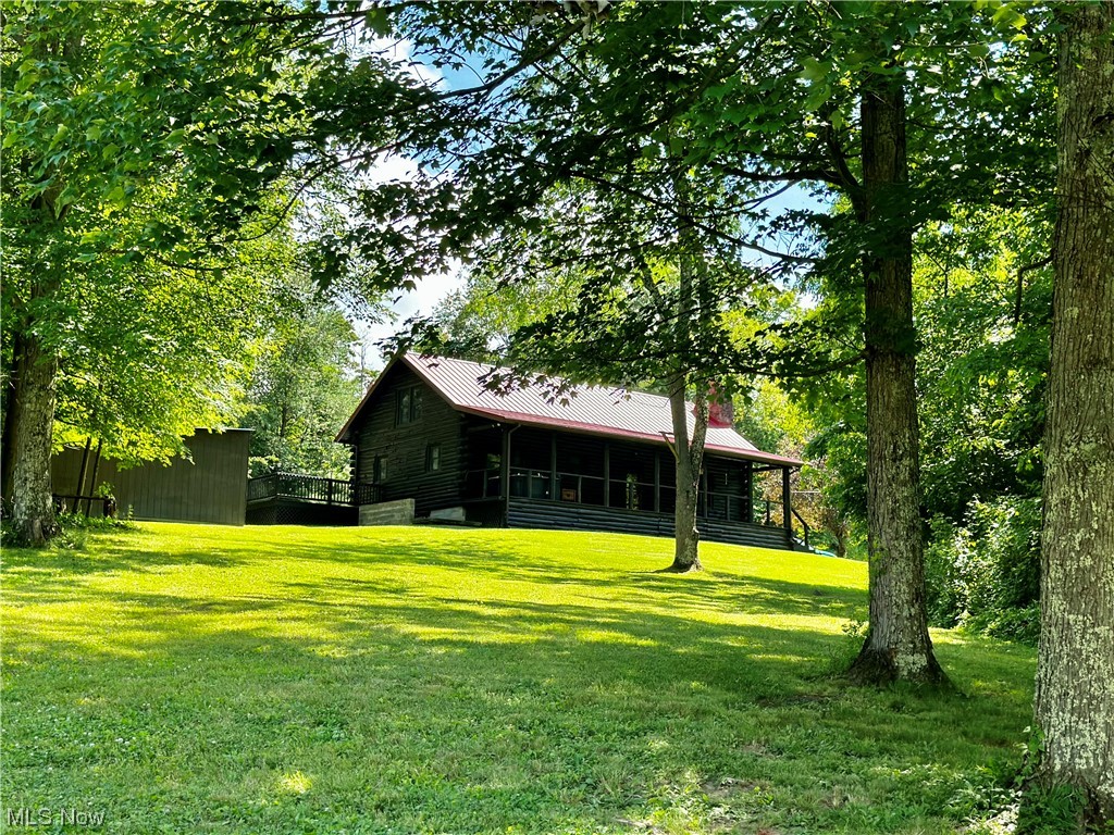 Log home living at its best!! Custom built by Pariso Log Homes of Sugarcreek, OH and perched upon 5.13 acres of waterfront property! With almost 800 ft of frontage on the Bethesda Reservoir you'll have endless opportunities to fish, kayak or canoe from your own front yard. There are also wooded walking trails and a cozy hidden firepit area to enjoy evening s'mores with friends and family. Take in the water views and the abundant wildlife from your private hot tub. The deer, turkey, squirrel and fox are frequent visitors here! Outdoor living space is abundant with a 40-foot covered front porch and the 60-foot wrap around deck in the back yard. Inside you'll find traditional log home cathedral ceilings, a woodburning fireplace and the original wide plank tongue and groove wood flooring. A few recent updates include a new metal roof March 2023, all new Window World Windows 2021, remodeled main bath 2021, gutters and downspouts 2021, Keim lumber interior doors 2021, Stained house & deck 20