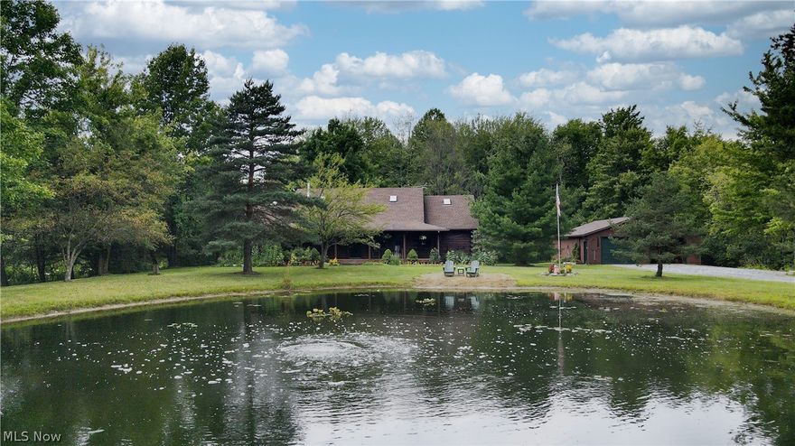 Welcome to your private log cabin resort on 5 acres! Walk up to the covered front porch and watch the sunrise over the large fully stocked pond while listening to the water wheel fountain as you enjoy your morning coffee. Enter this home and you’re going to fall in love with the open floor plan with soaring ceilings and wood beams and hardwood floors. The great room has 2-story ceilings, a stone wall and newer soap stone wood burning stove. The formal dining room is located right off the large kitchen that features high ceilings, hickory cabinets and stainless appliances. Step in the side entrance into the conveniently located mud room and large laundry room. On the opposite side of the first floor, you will find the master suite complete with vaulted & timber framed wood ceilings, a large walk-in closet and private full bath. You’ll also find an office that can be another bedroom. Sit on the screen in porch or hop in the hot tub and enjoy the park-like backyard where you can enjoy a w