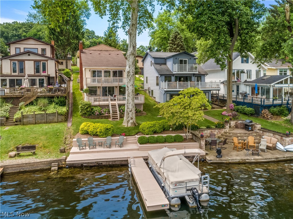 Exceptional lakefront on East Reservoir, main chain of Portage Lakes* Lovely open floor plan with magnificent views having 4 bedrooms/3 baths, approx. 2913SF including finished walkout lower level, 1st floor master & laundry, 2 kitchens, 3 car garage (1 attached/2 detached) & mega parking* Striking entry from the covered front porch with ceramic floor & open staircase* Great room with stone gas log fireplace* Eat in kitchen with full wall of windows including 2 sliding doors & access to balcony/deck overlooking the lake, fully applianced, pantry & ceramic floor* Upper level with 2 bedrooms plus loft/bedroom used as an office & full bath* Lake views from lower level family room with window wall including slider & access to partially covered deck, applianced kitchen with breakfast bar & full bath* Unfinished basement includes work benches, cabinets & shelves* Lake side landscaping & deck leading to 25' dock* Absolutely mint move in condition*