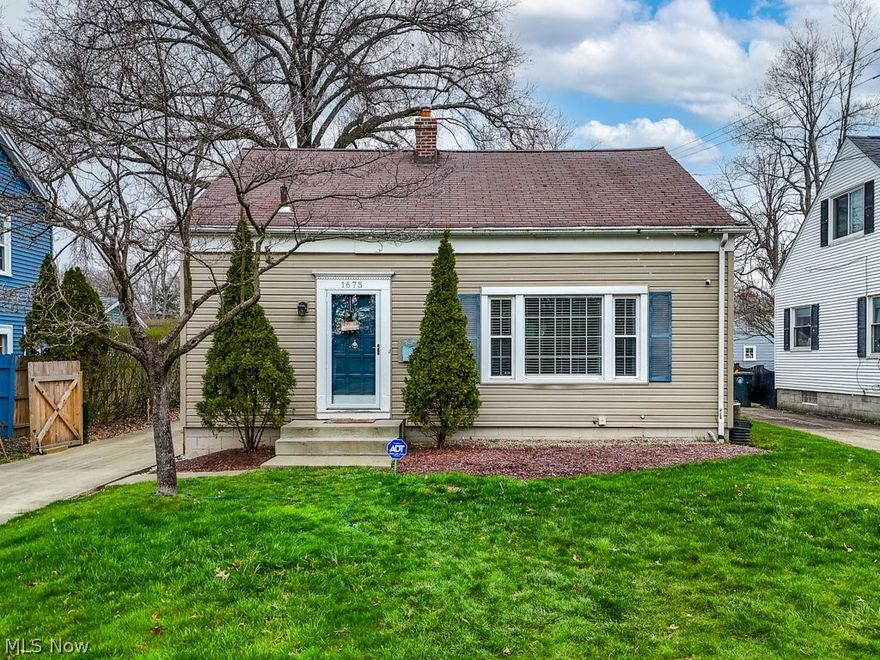 Wiltshire Road is a West Akron favorite, located minutes from both Metro-parks and Wallhaven; and marked by the infamous Blue Line of the Marathon. Don't be deceived by the understated entrance which throws off cottage vibes. This home is much larger than it appears! More split-level than Cape Cod, you can easily entertain friends or escape to a nook for coffee. And if you're a fan of built-in cabinets, look no further. Three of the rooms have been appointed with bookcases for organization or decoration - never install another shelf! Expect the front family room to have recently stained hardwood floors and abundant light. Up the stairs takes you to the three bedrooms and full bath. Down a few stairs and you are in the dining room with a unique ceiling and chandelier, with a ledge trimming the room - perfect for succulents! Off the dining room is the kitchen, where you can gaze at the courtyard from the window above the sink. This level also shares a large living room. It might seem a bit more formal since it's dressed up with navy built-ins and ceramic tile floors, but this space could be used for just about anything. Peek around the corner to see the lovely half bath and basement entrance. The backside of the house is beyond adorable with its darling sunroom, with built-in features. Don't miss the stamped concrete patio out back - a great place to grill or chill. While we can't show you more grass with the fenced-in yard; you can still imagine that once the weather breaks this house has the perfect set up for both privacy and fun. There is also a spacious, detached 2-car garage. The gated driveway is a unique touch, making this home a must-see.