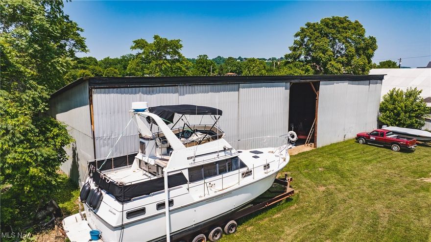 Discover a rare opportunity to own a commercial marina property at a prime corner in Williamstown, WV. This offering includes three level lots totaling approximately 9,324 sq ft, improved with a 10,352 sq ft metal building. Currently home to Al-Cott Marine Service – a well-known local boat repair and storage business established in 1969 the site carries a legacy of service to the boating community. The property is ideally situated just steps from the Williamstown public boat ramp on the Ohio River, providing unparalleled convenience for boaters & water enthusiasts. With flexible zoning that allows both commercial and residential use, this property offers tremendous potential for a variety of ventures in a high-visibility, riverside location. Land & Building: Three combined lots with a spacious 10,352 sq ft metal building perfect for boat repair, storage, or conversion to other uses. Dimensions approx. 148’ x 63’ for the total site. Prime Corner Location: High-visibility corner of WV Route 14 and Dodge Ave, with approximately 148 ft of road frontage. Steps from the public boat ramp and Ohio River access, attracting boating and fishing traffic to the area. Established Marine Business: Currently operating as Al-Cott Marine Service, a trusted local marine repair/storage facility in continuous operation since 1969. The longevity and reputation of this business underscore the commercial appeal and community presence of the site. Flexible Zoning: Zoned for commercial or residential use, offering versatility for redevelopment or new ventures. (Note: City zoning prohibits use as a medical marijuana dispensary or adult entertainment venue, preserving a family-friendly business environment. Utilities: Electrical service on-site (power is connected and in use). Public water and sewer utilities are available in the area, simplifying any future development or occupancy needs. The existing building is ready for your operations with utilities in place.