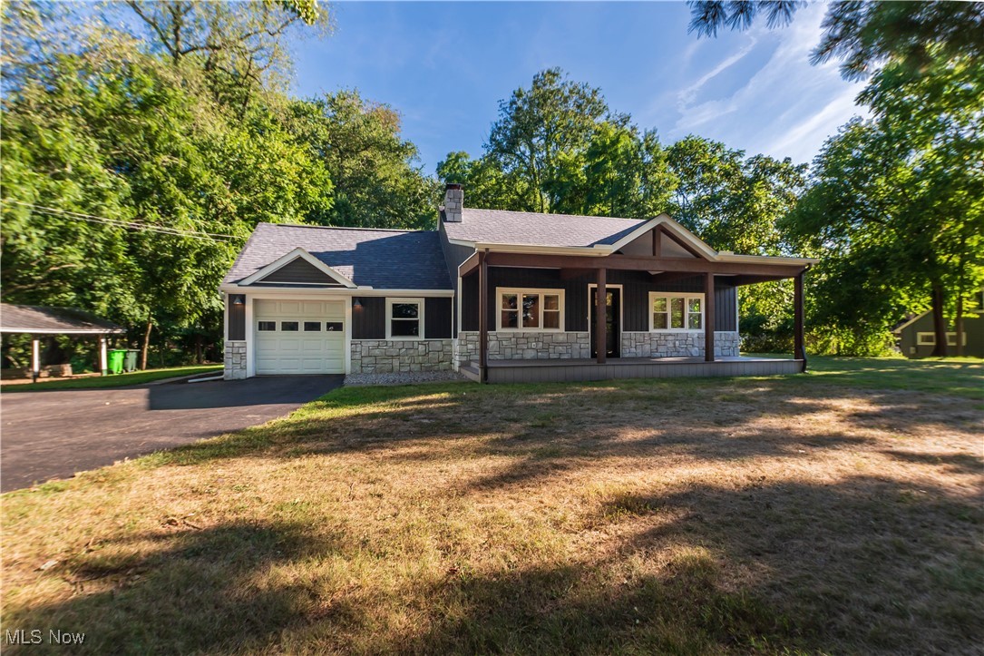 Welcome to 1050 Easthill St SE. Set on 1.36 acres of wooded privacy, this fully remodeled bungalow-style home blends charm, comfort, and modern finishes in one beautiful package. Originally built in 1950 and completely updated in 2021, every detail has been thoughtfully done so you can move right in and enjoy it. The inviting front porch spanning the width of the home sets the tone, perfect for morning coffee or evening relaxation during the sunset. Step inside to a bright living room with stunning wood-accented ceiling cathedral ceilings, and a cozy fireplace.
The heart of the home is the gorgeous kitchen, featuring granite countertops, custom cabinetry, stainless steel appliances, and a spacious island with seating. Sliding glass doors open to the backyard, making it easy to enjoy the peaceful wooded surroundings. This home offers 2 bedrooms and 3 full bathrooms, with a third bedroom in the finished basement. The lower level also adds 384 sqft of living space, perfect for a guest suite, rec room, or media area. Each bathroom has been beautifully remodeled with modern vanities, custom tile work, and updated fixtures, giving the home a fresh, luxurious feel.
With its blend of modern updates, private wooded lot, and unbeatable location near shopping, dining, and excellent schools, this property offers both privacy and convenience—an ideal place to call home. Come see for yourself how peaceful and move-in ready this home is—call today and make 1050 Easthill St SE your new retreat in North Canton.