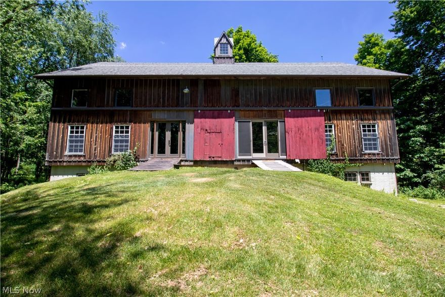 Opportunities do not come up like this often!  The possibilities are endless at 500 Wally Rd. Loudonville.  This one-of-a-kind home was constructed in 2006 from the timbers of a 100-year-old Wayne County barn.  Christian and Sons, Inc tore apart the barn piece by piece and rebuilt it on its new foundation in Loudonville on a private oasis.  Just look up at the beautiful ceiling that was made from trees off the 16-acre area that was partially cleared to rebuild the barn.  (Current owner was told the barn is a sister barn to the Blue Barn Winery in Shreve.)  This property is currently being used as a home, but the possibilities are endless for an event venue, Airbnb, investment property, and many more.  First floor is completely open and features a large full bath, kitchen area, and doors leading to large deck that overlooks the woods.  Basement boosts 4 bedrooms, 1.5 bath, laundry room, storage room, unfishished living area, and 3 outdoor entrances.  Bring your finishing touches and cre